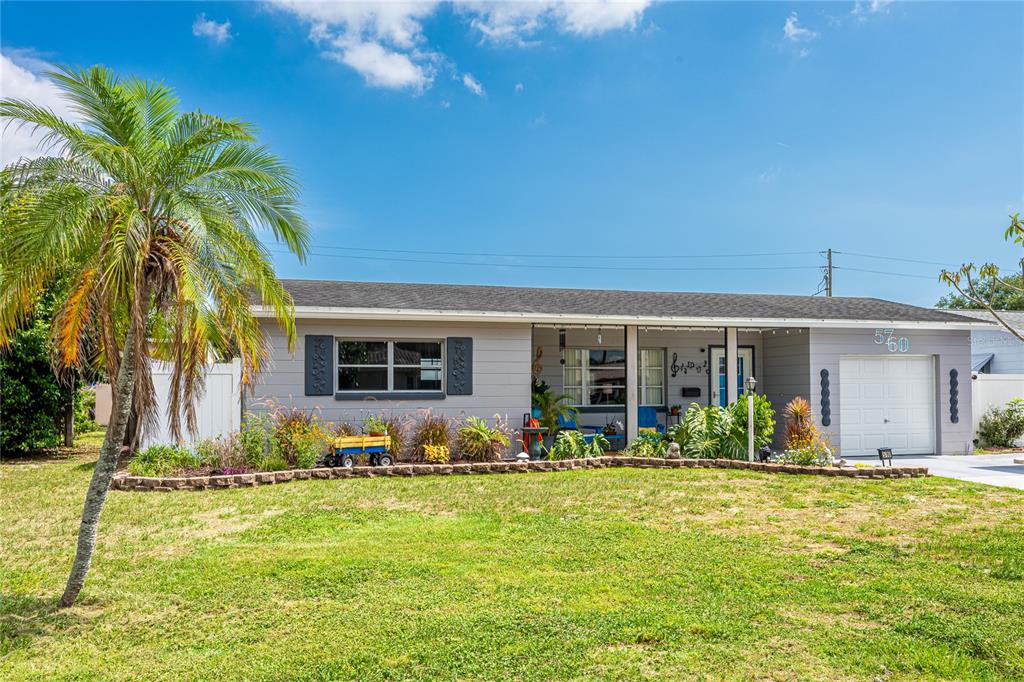 A kitchen with a central island, stainless steel appliances, and blue walls on tile flooring — 5760 3RD AVENUE N, ST PETERSBURG, FL