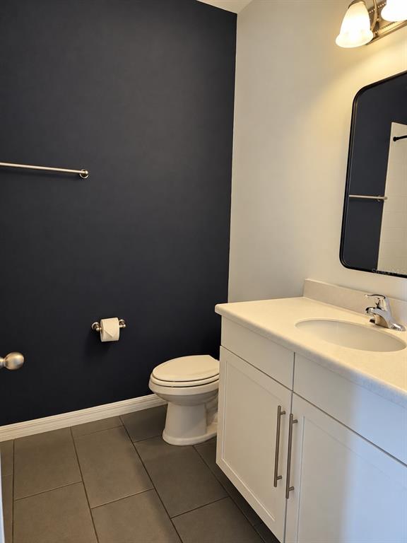 A bathroom features a dark blue accent wall, a white vanity, and gray floor tiles — 11649 WATER RUN ALLEY, WINDERMERE, FL