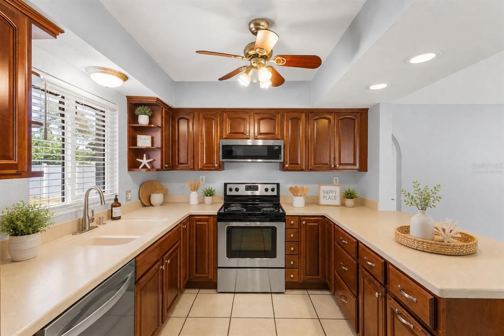 A bright living room features light gray walls, large windows, and beige tiled flooring — 605 S FLORIDA AVENUE, TARPON SPRINGS, FL