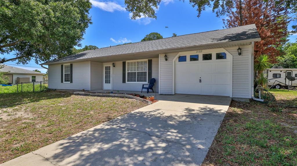 A single-story house with light gray siding, a concrete driveway, and an attached garage — 3103 JUNIPER DRIVE, EDGEWATER, FL