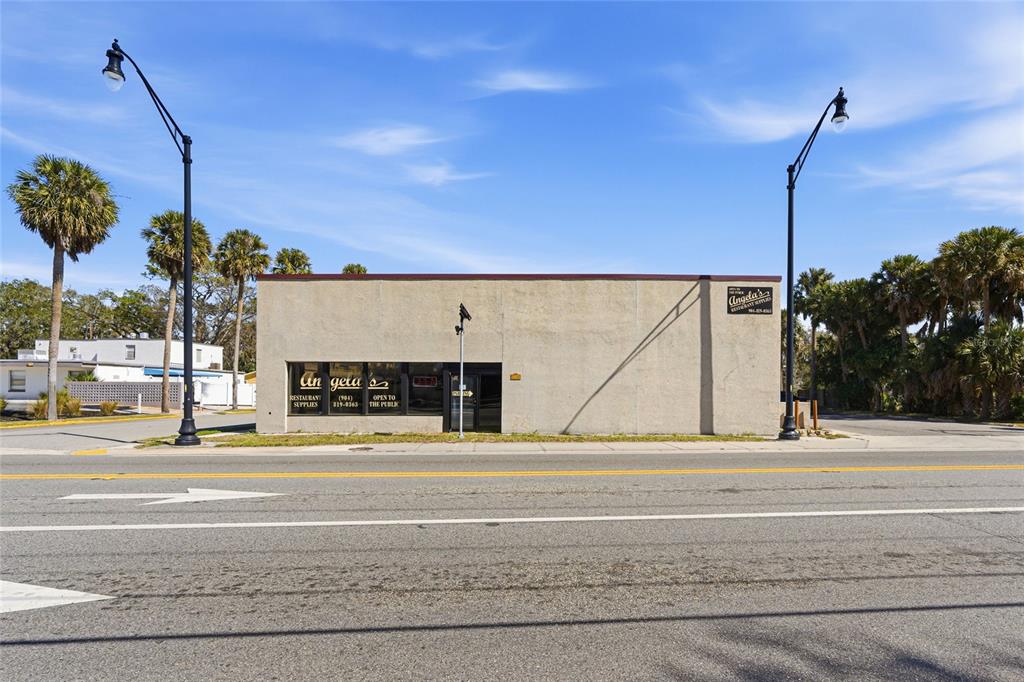 A single-story commercial building with a tan stucco facade sits along a paved road — 185 SAN MARCO AVENUE, ST AUGUSTINE, FL