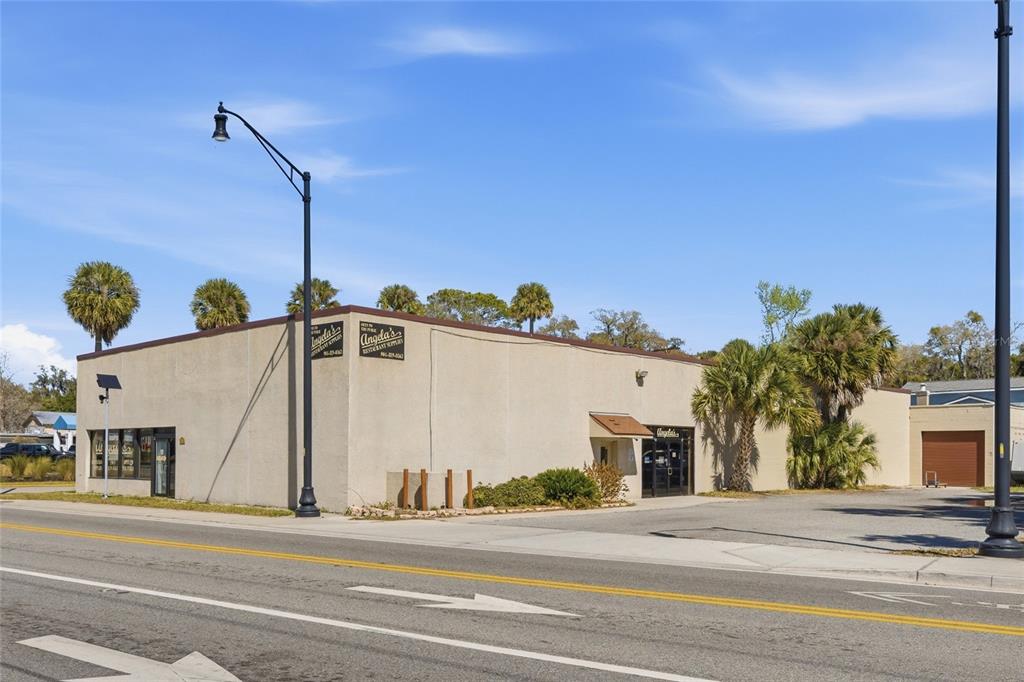 A commercial building with a tan exterior and palm trees sits beside a paved road — 185 SAN MARCO AVENUE, ST AUGUSTINE, FL