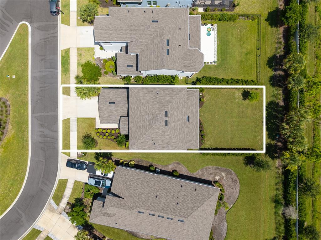 An aerial view shows a residential house with a fenced backyard and a driveway — 9284 TEQUILA SUNRISE DRIVE, SARASOTA, FL