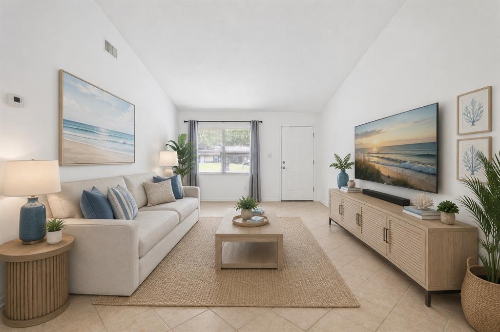 A living room with a beige sofa, wooden coffee table, media console, and coastal decor — 1923 BONNEVILLE DRIVE, ORLANDO, FL