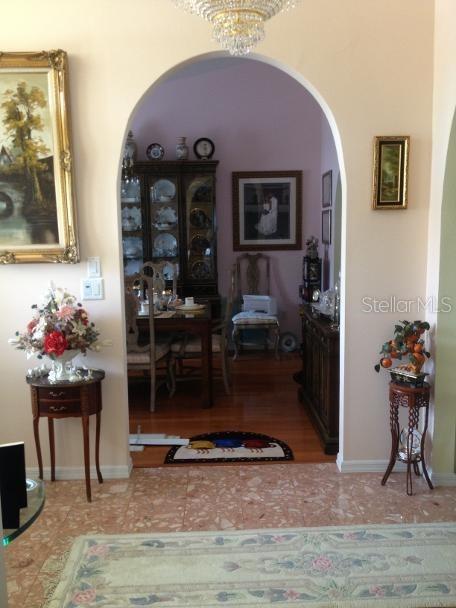 An arched doorway leads from a tiled foyer into a dining room with wood floors — 8 SUTTON CT, PALM COAST, FL