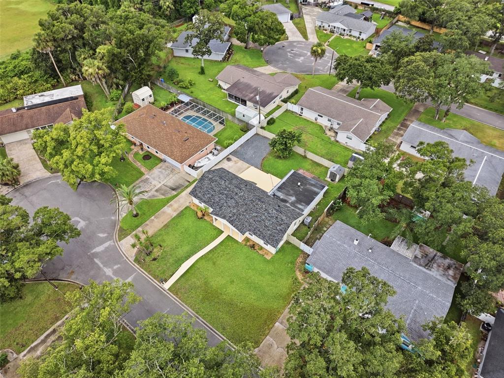 An aerial view shows several suburban houses with yards, driveways, and trees in a neighborhood — 59 CRESTWOOD CIRCLE, ORMOND BEACH, FL