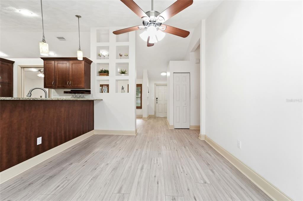 A dining area with light wood-look flooring, a ceiling fan, and a built-in display shelf — 59 CRESTWOOD CIRCLE, ORMOND BEACH, FL