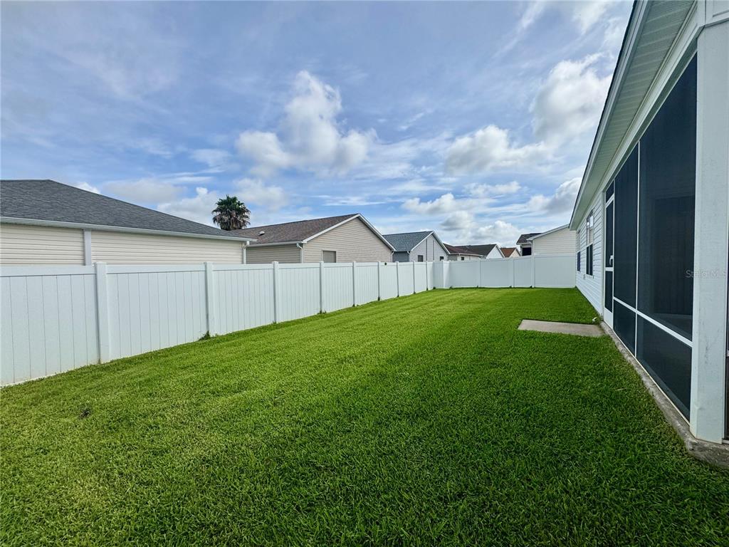 A single-story house with white vinyl siding, a one-car garage, and a concrete driveway — 892 NASH LOOP, THE VILLAGES, FL