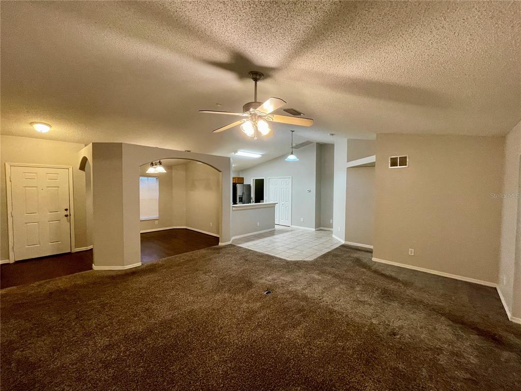 A living room with carpeted flooring, a ceiling fan, and an adjacent dining area — 12119 WARWICK CIRCLE, PARRISH, FL