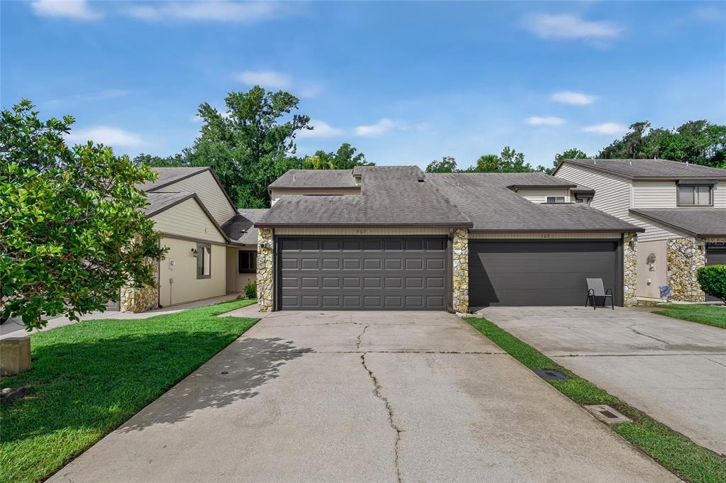 A two-car garage with a concrete driveway in front of a suburban residential home — 367 CASTLEWOOD LANE, NEW SMYRNA BEACH, FL