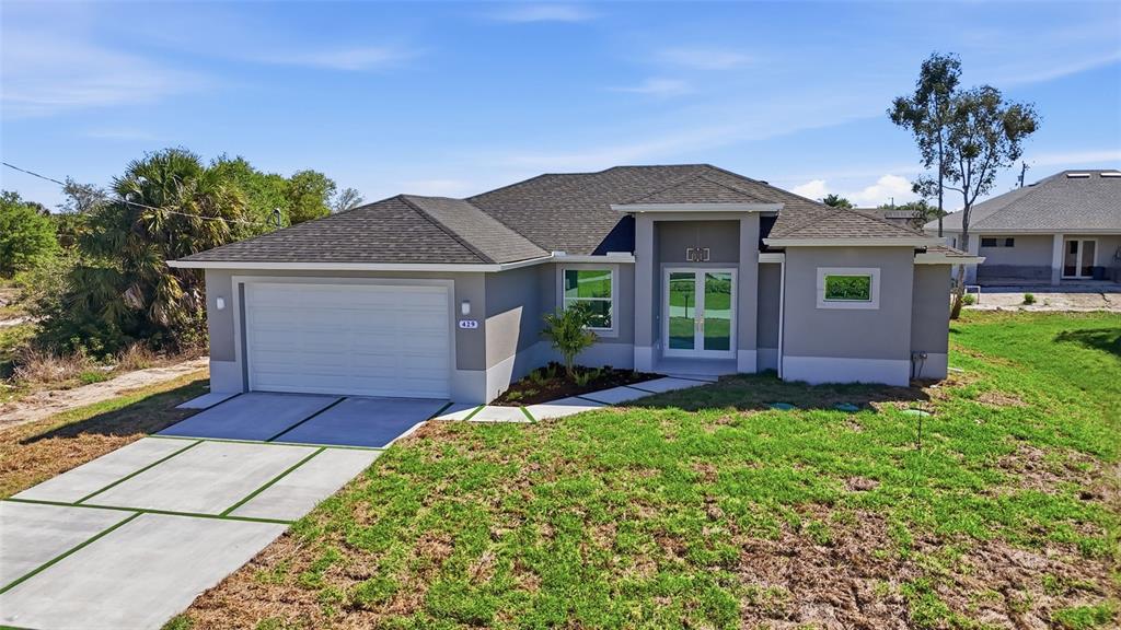 A single-story house with a gray exterior, a two-car garage, and a front entryway — 429 PALMYRA AVENUE, LEHIGH ACRES, FL