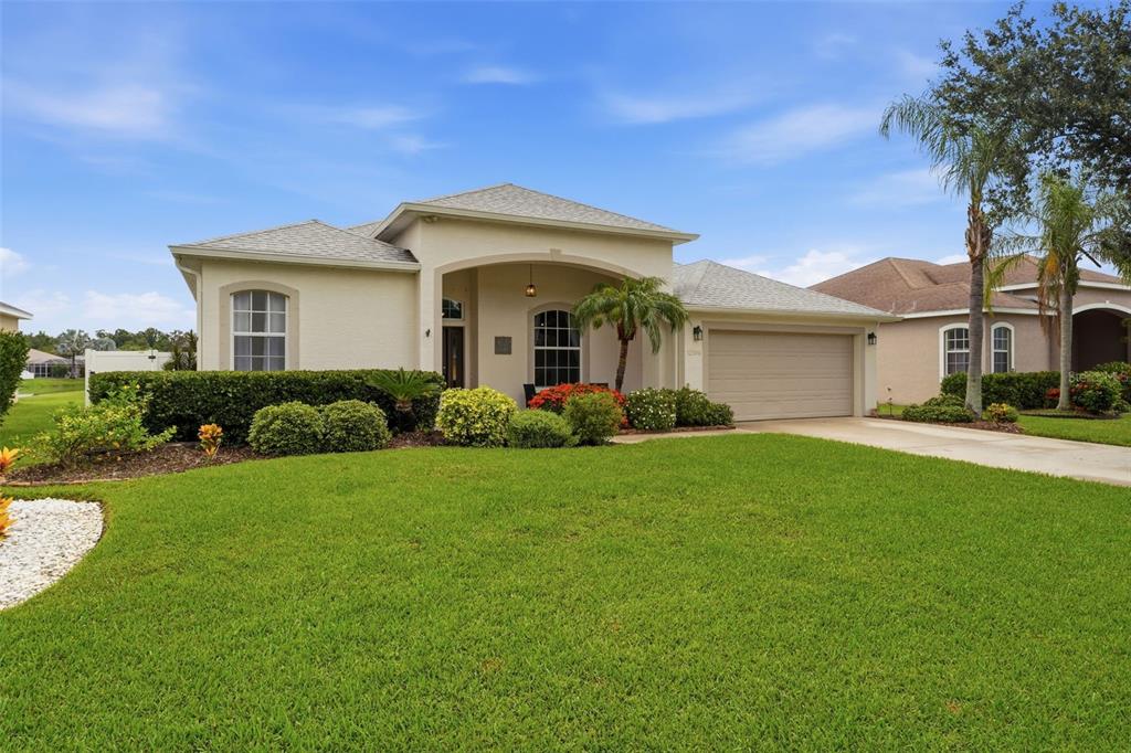 A single-story suburban house with a beige stucco exterior, a two-car garage, and a driveway — 12506 25TH COURT E, PARRISH, FL