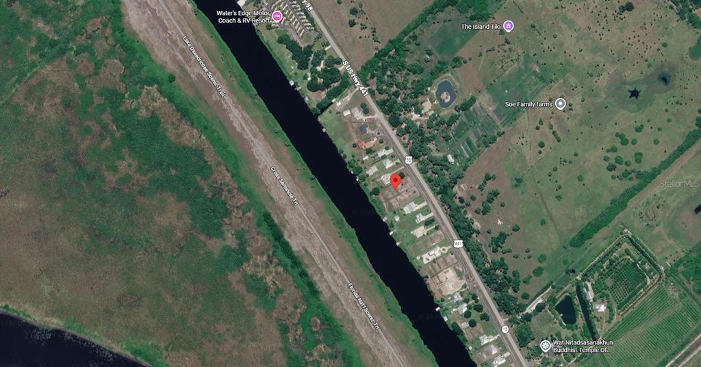 This is a satellite map view showing a vacant residential lot marked with a red pin — 13050 US HIGHWAY 441 SE, OKEECHOBEE, FL