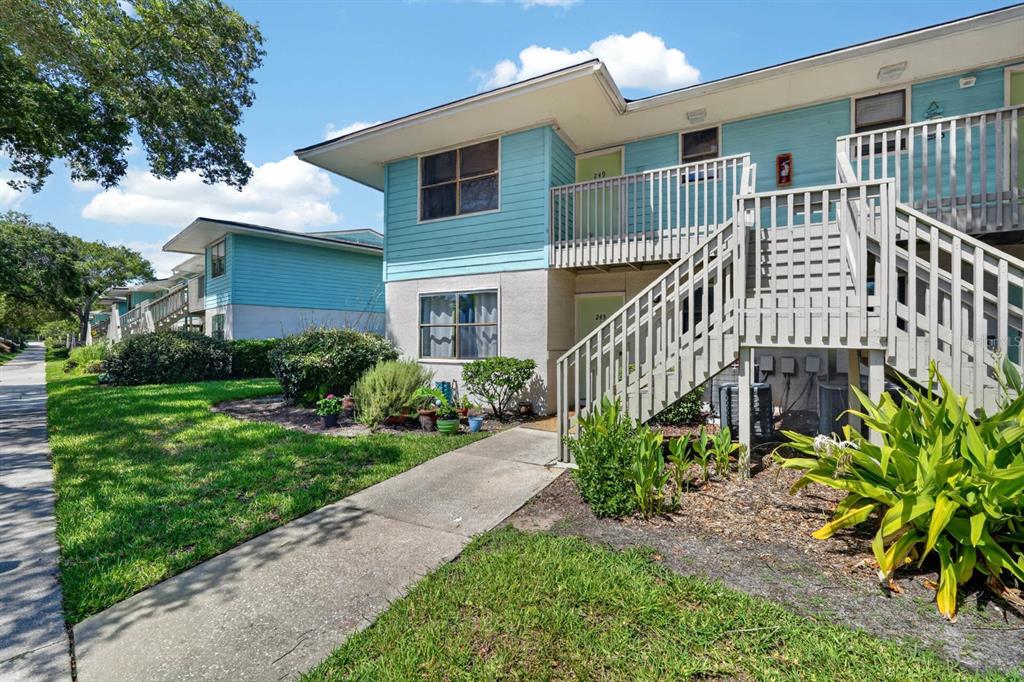 A two-story apartment building with light blue siding, wooden stairs, and a concrete walkway — 650 W POPE ROAD UNIT 249, ST AUGUSTINE BEACH, FL