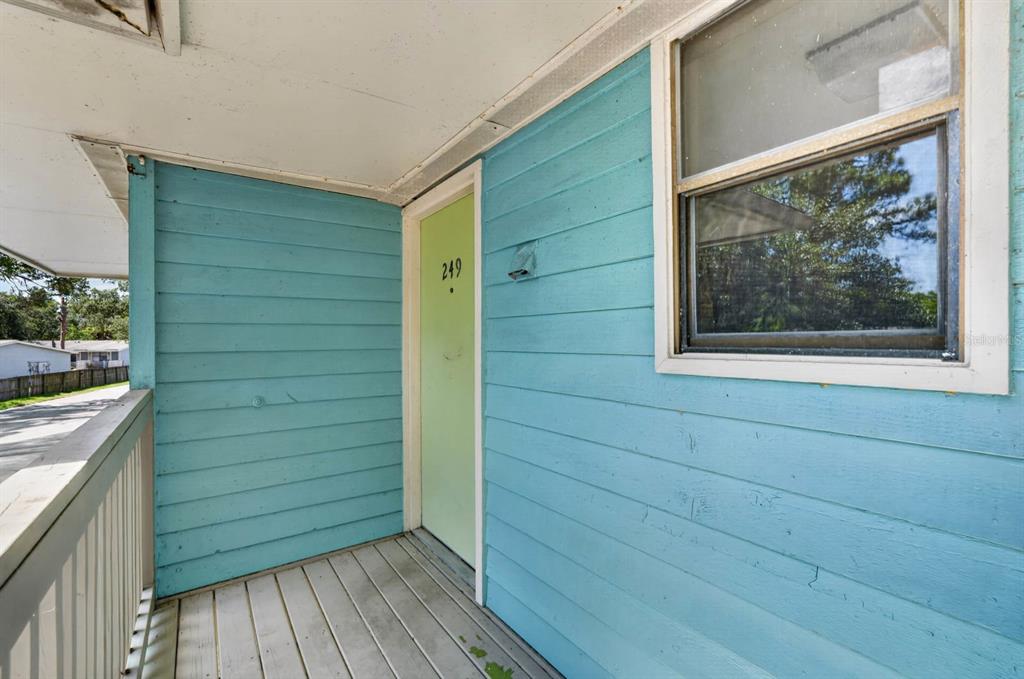 A turquoise-sided exterior wall features a light green door numbered 249 and a window — 650 W POPE ROAD UNIT 249, ST AUGUSTINE BEACH, FL
