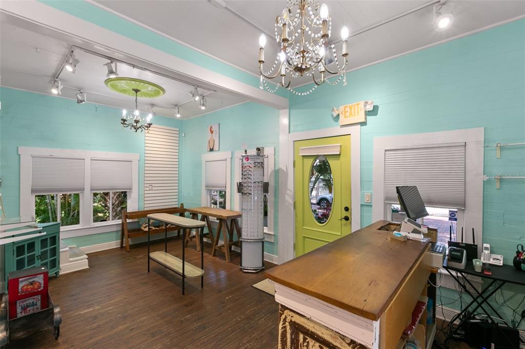 A retail space with light blue walls, wood floors, a chandelier, and a front desk — 135 4TH AVENUE N, SAFETY HARBOR, FL