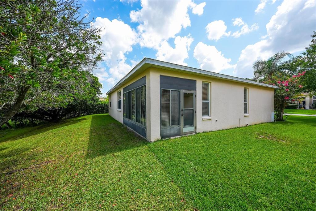The exterior of a house features a screened-in porch, stucco walls, and a grassy yard — 2428 WALNUT HEIGHTS ROAD, APOPKA, FL