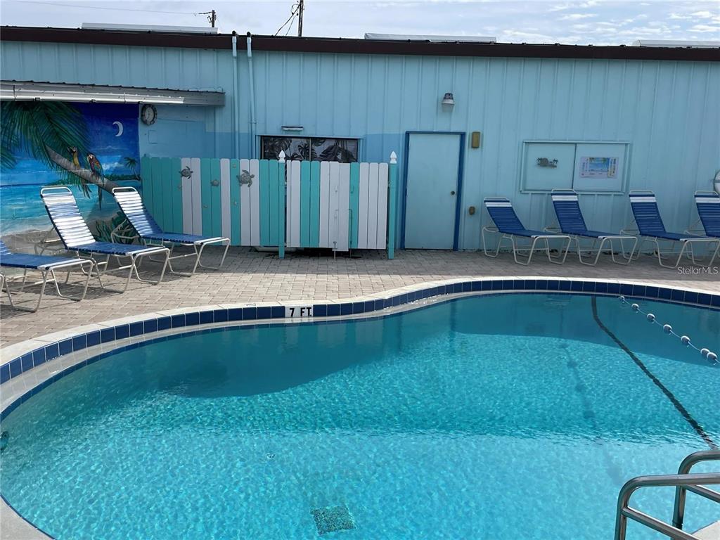A swimming pool with lounge chairs sits in front of a light blue building — 163 NEW YORK STREET, PALMETTO, FL
