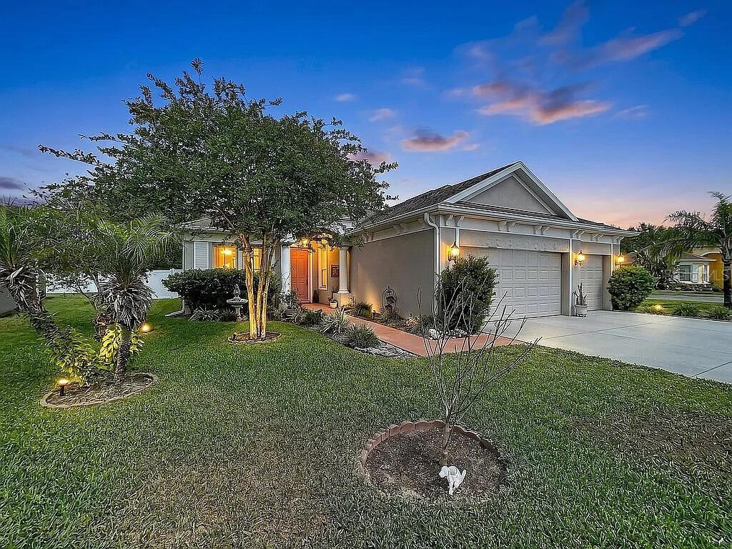 A single-story suburban house with a two-car garage and a landscaped front yard at dusk — 14530 BALLOCH DRIVE, HUDSON, FL