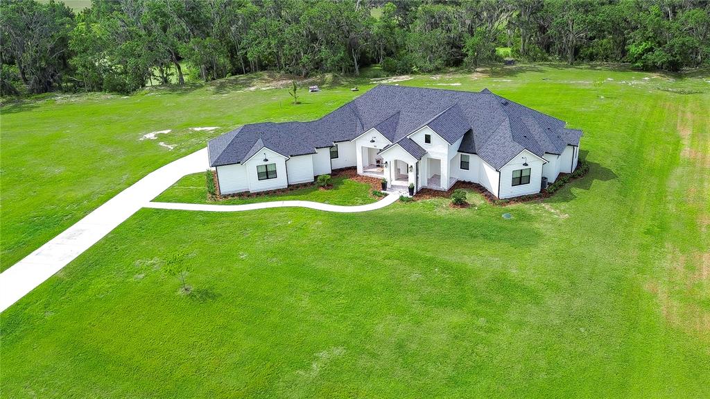An aerial view of a white single-story house with a dark roof on a lawn — 111 ALAFIA ESTATES LANE, LITHIA, FL