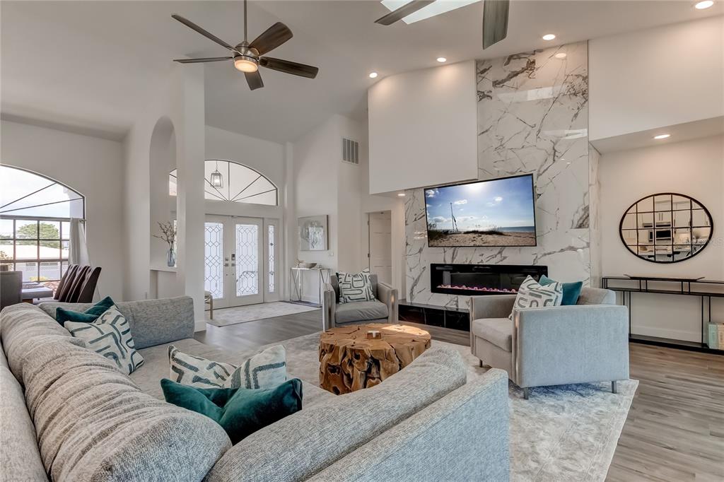 A modern kitchen features a marble-topped island, white cabinetry, and an adjacent dining area — 112 LEEWARD ISLAND, CLEARWATER, FL