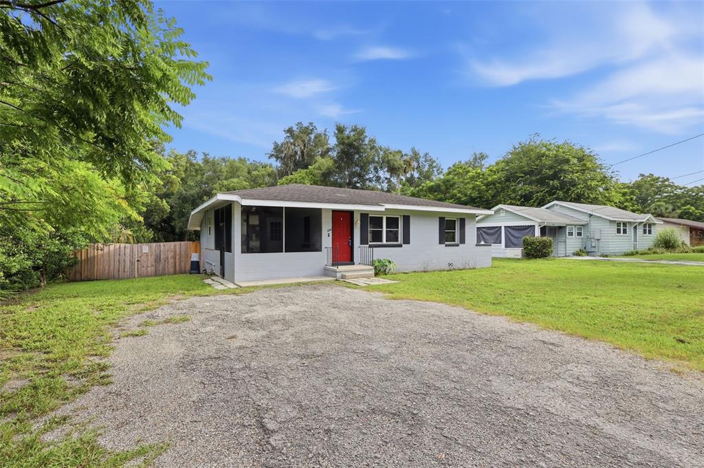 A bathroom features a vanity, a bathtub with a showerhead, and tiled walls — 320 W GRAVES AVENUE, ORANGE CITY, FL