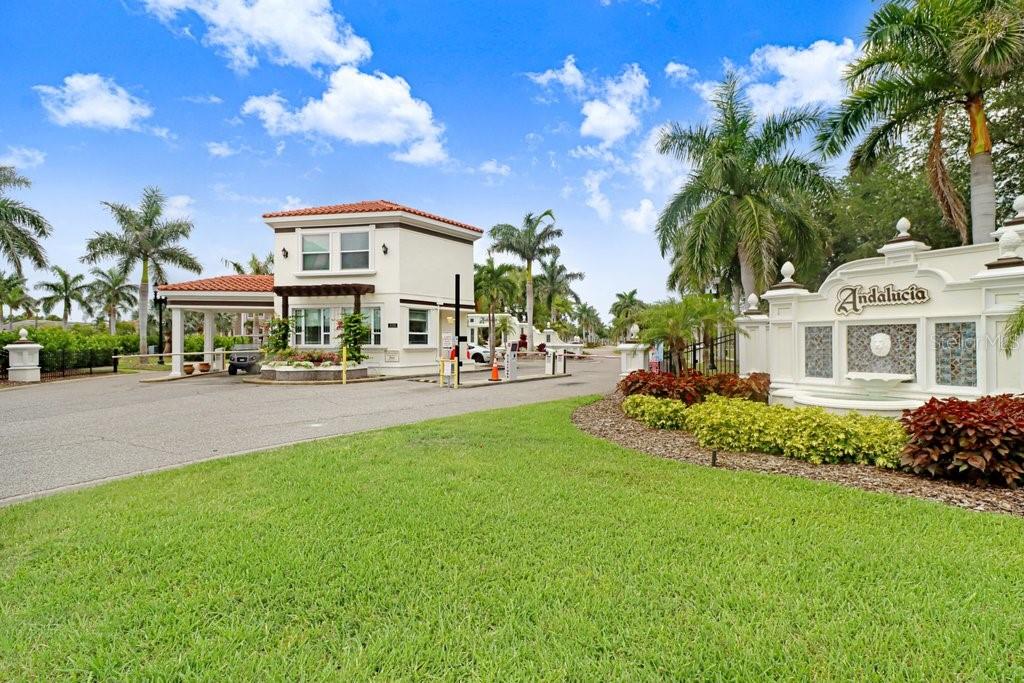 The entrance to the Andalucia community features a guardhouse, palm trees, and a decorative sign — 6104 LAGOMAR LANE, APOLLO BEACH, FL