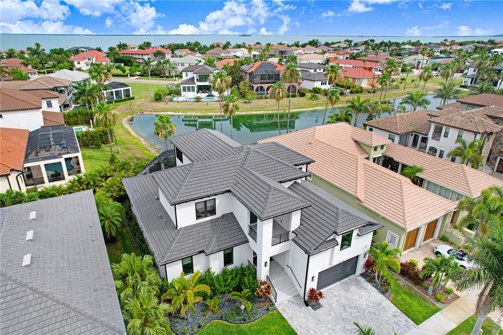 An aerial view shows a modern white two-story house with a dark tiled roof — 6104 LAGOMAR LANE, APOLLO BEACH, FL