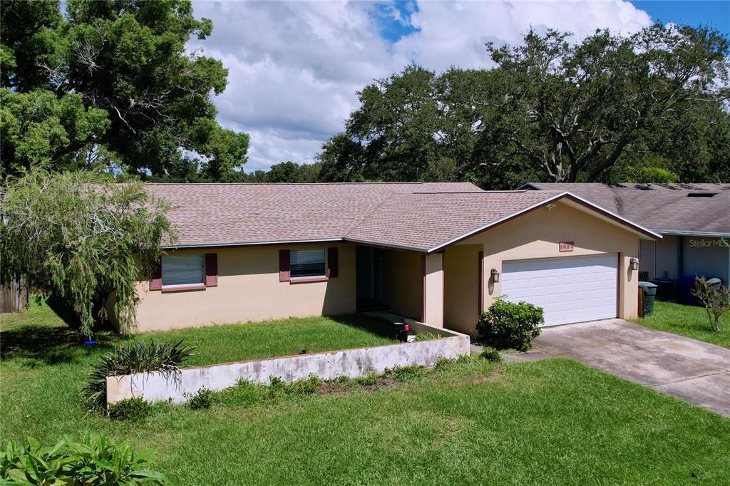 A single-story house with a tan exterior, a shingled roof, and an attached two-car garage — 1622 DALE CIRCLE S, DUNEDIN, FL