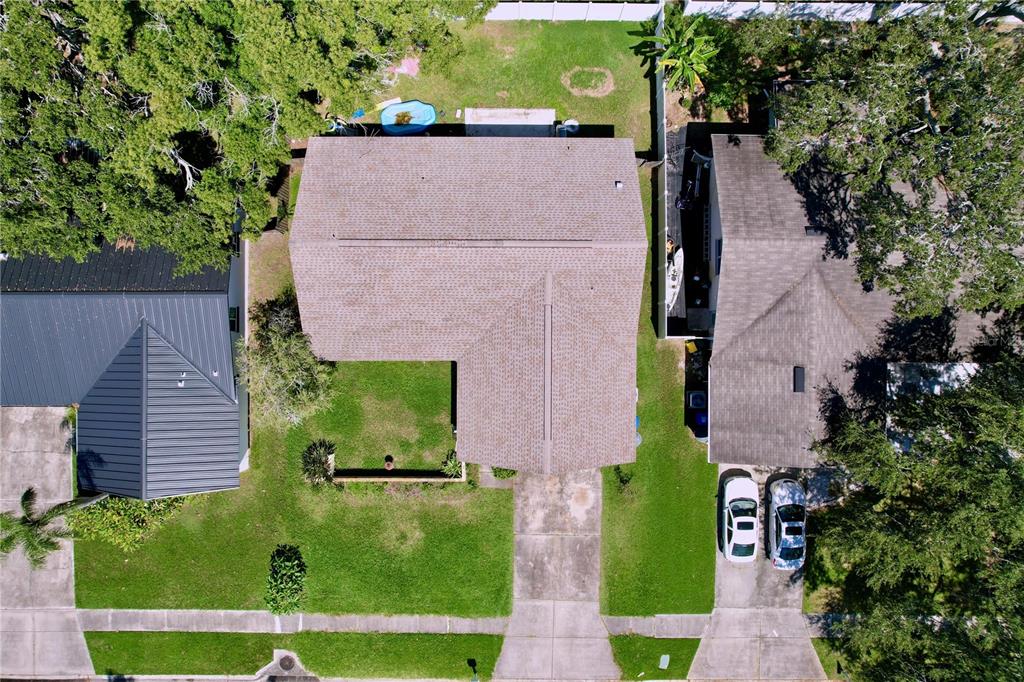 An aerial view shows a house with a shingled roof, driveway, and surrounding green lawn — 1622 DALE CIRCLE S, DUNEDIN, FL