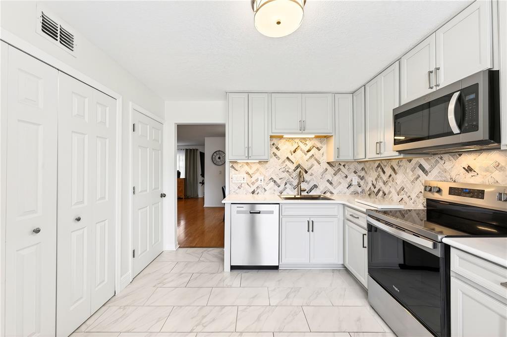 A two-story yellow townhouse with a front walkway and manicured hedges — 2218 MCMAHON COURT UNIT 1038, ORLANDO, FL