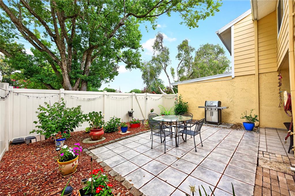 A row of two-story townhouses with yellow siding, green hedges, and a parking lot — 2218 MCMAHON COURT UNIT 1038, ORLANDO, FL