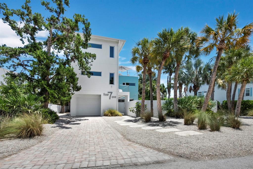 A modern white three-story house with a garage and palm trees in the front yard — 471 ISLAND CIRCLE, SARASOTA, FL