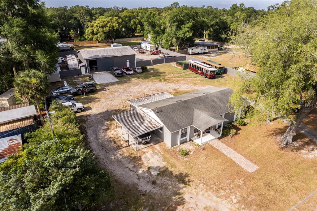 An aerial view shows a house with a carport, a detached garage, and several vehicles — 20024 STATE ROAD 44, EUSTIS, FL