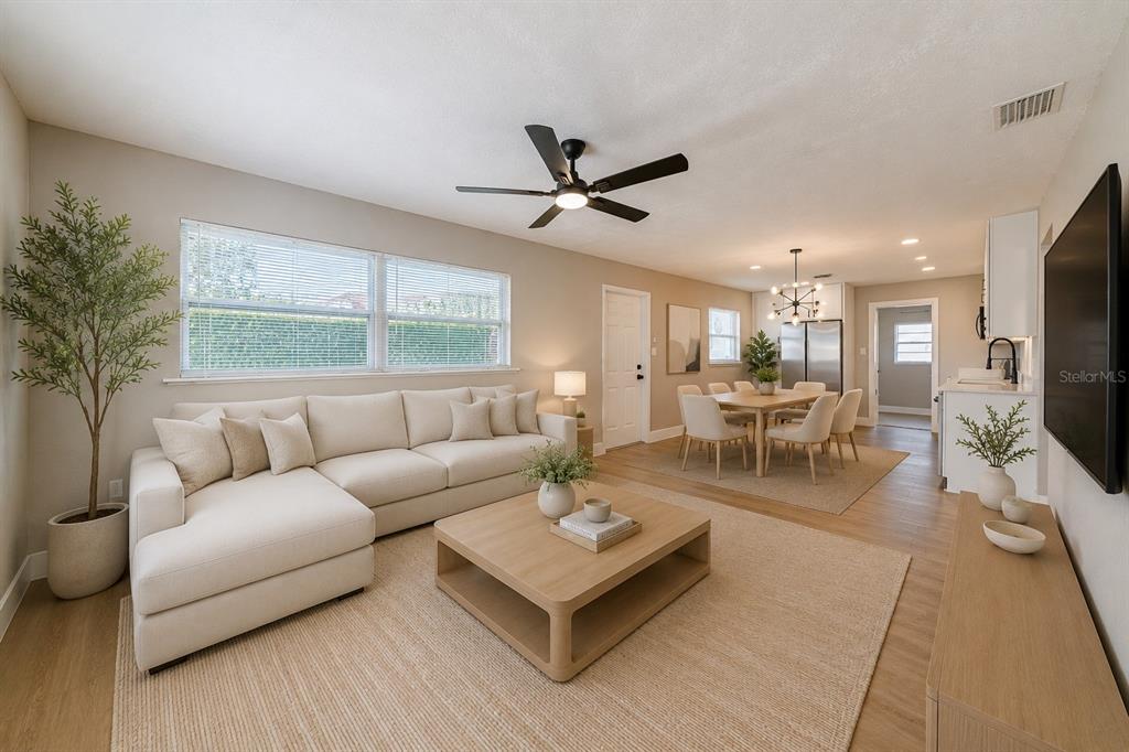 A living room with a sectional sofa, coffee table, and adjacent dining area with light flooring — 703 S DIXIE AVENUE, FRUITLAND PARK, FL