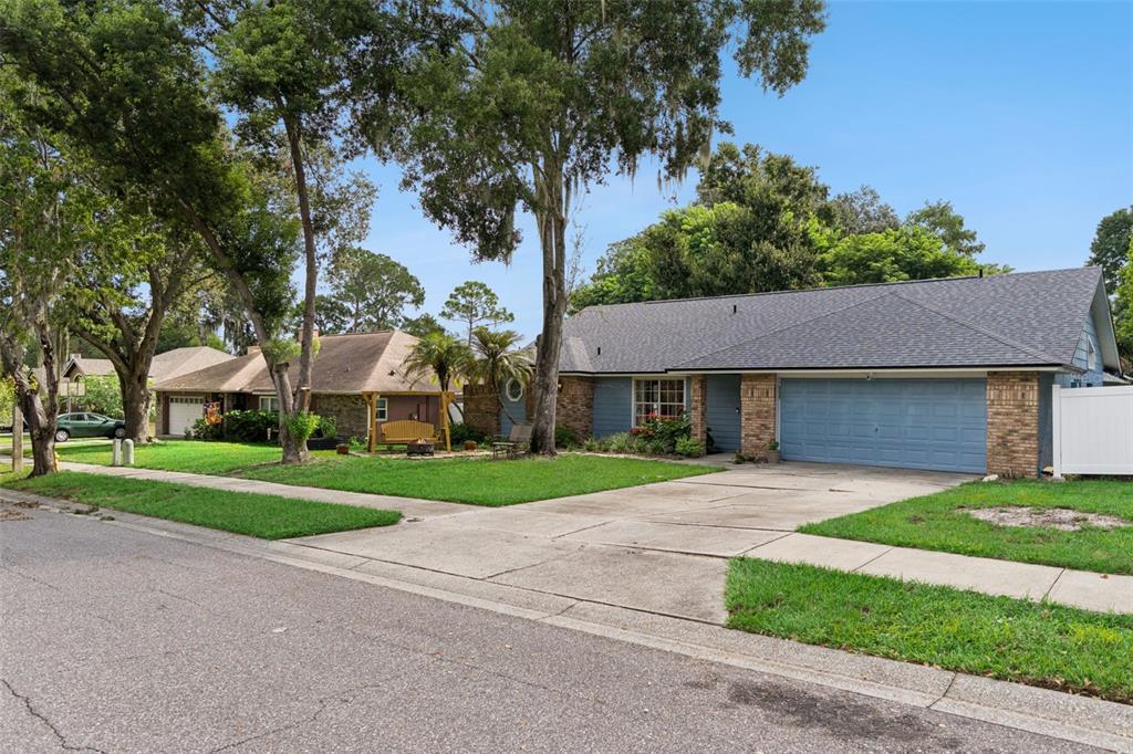A single-story house with a blue garage door and brick accents sits on a grassy lot — 217 HARBOR DRIVE, WINTER GARDEN, FL