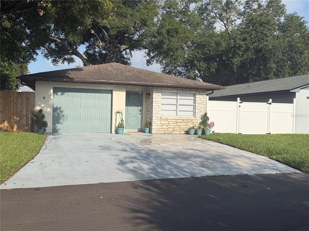 An aerial view of a single-story house with a blue garage door and stone facade — 536 HIBISCUS WAY UNIT 7B, ORLANDO, FL