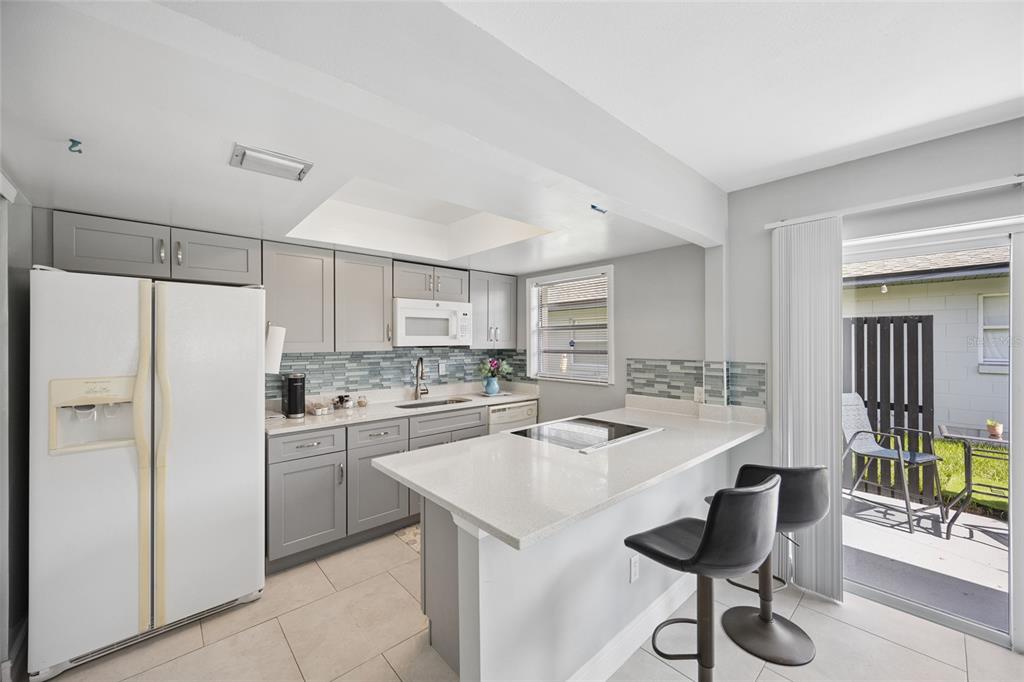 A single-story house features a blue garage door, stone facade, and a wooden privacy fence — 536 HIBISCUS WAY UNIT 7B, ORLANDO, FL