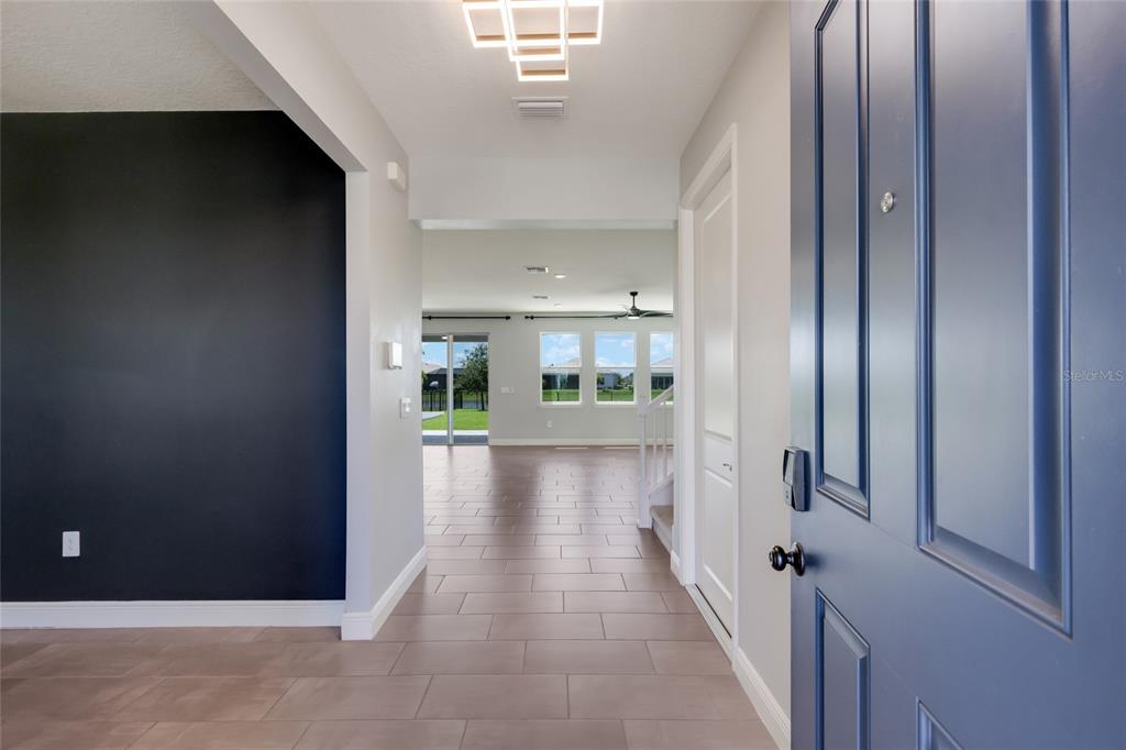 An entryway with tile flooring leads into a living area with large windows and views — 17828 GULF RANCH PLACE, LAKEWOOD RANCH, FL