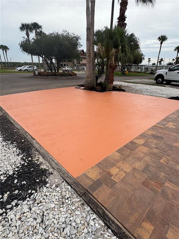 An outdoor space features a bright orange concrete pad adjacent to a paved walkway — 9000 US HIGHWAY 192 UNIT 327, CLERMONT, FL
