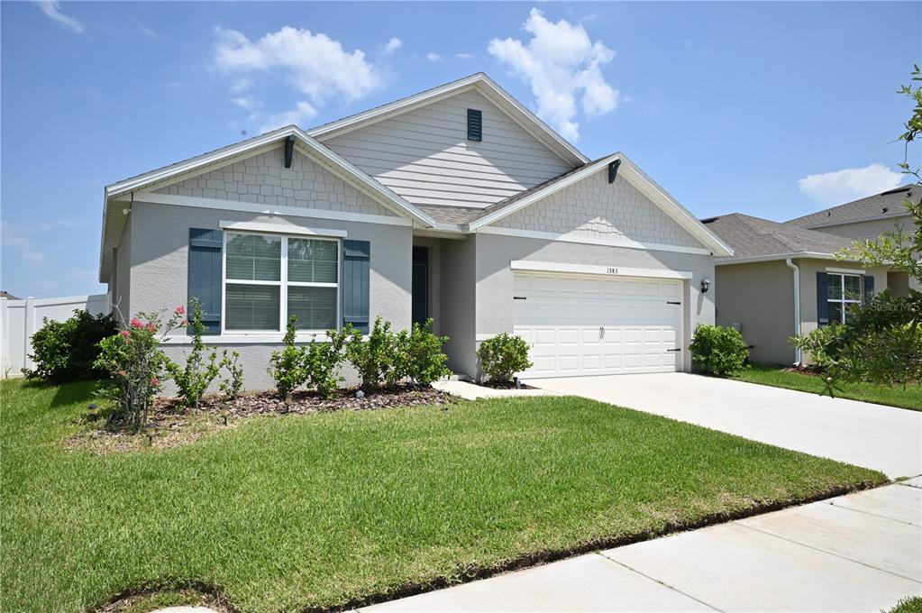 A living room features a dark gray sofa, a coffee table, and a ceiling fan — 1583 BARBERRY DRIVE, KISSIMMEE, FL