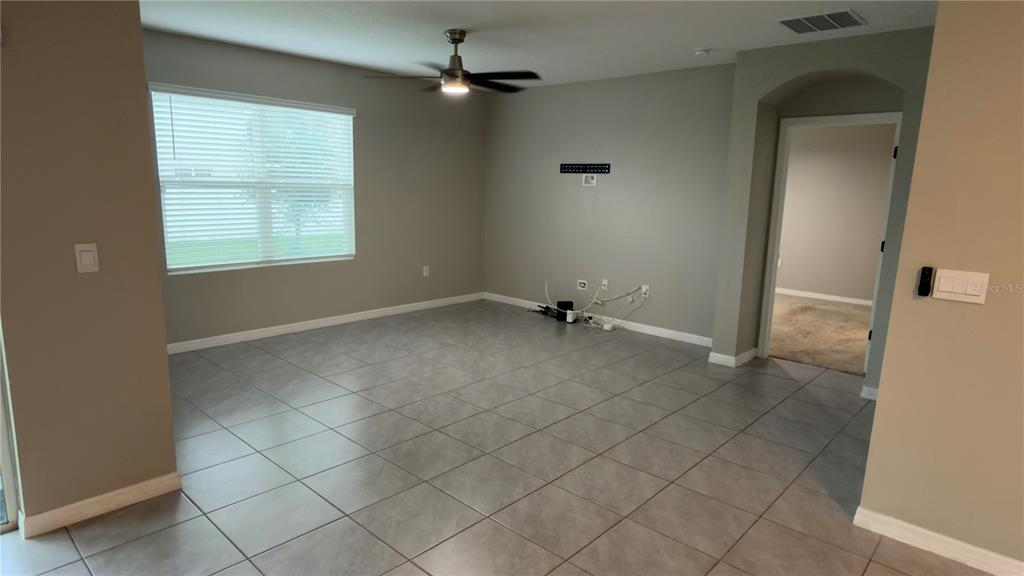 A home office features a desk with a computer, a television, and a leather sofa — 1583 BARBERRY DRIVE, KISSIMMEE, FL