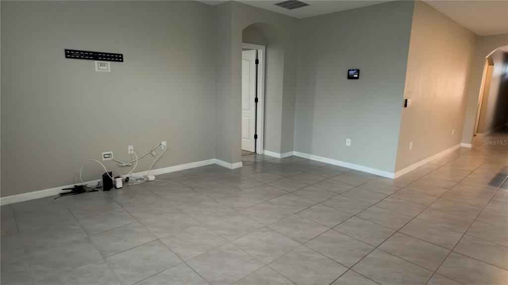 A living room features a gray reclining sofa, a dark media console, and a coffee table — 1583 BARBERRY DRIVE, KISSIMMEE, FL