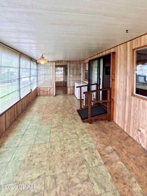 A sunroom features wood-paneled walls, a tiled floor, and a sliding glass door — 725 MARSHALL CIRCLE, PORT ORANGE, FL