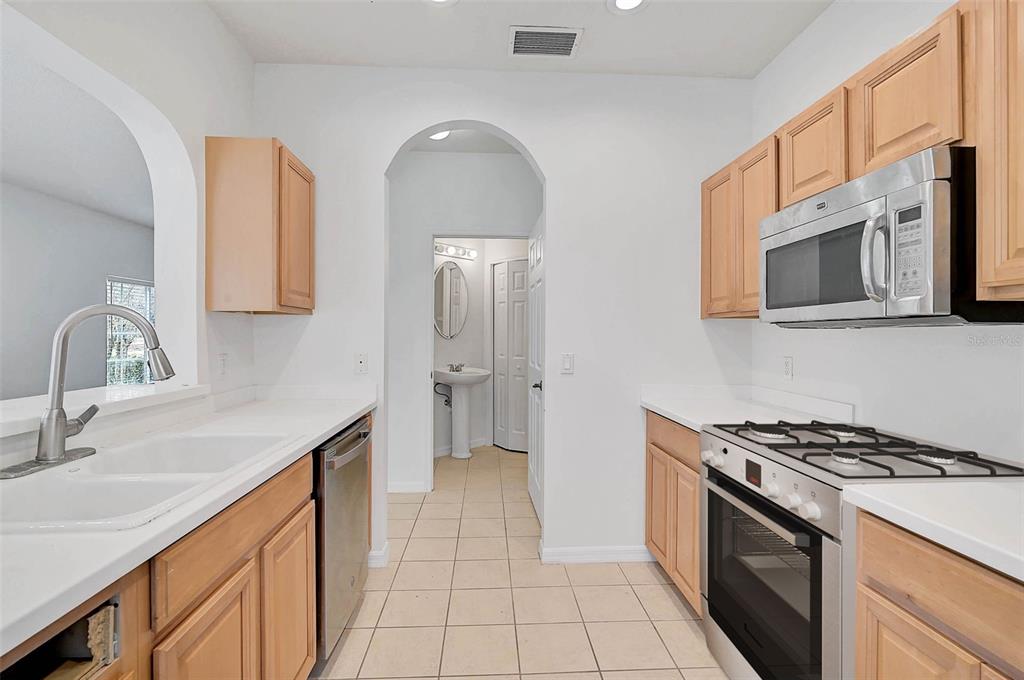 A kitchen with light wood cabinets, white countertops, and a gas range — 208 CAPE HARBOUR LOOP UNIT 108, BRADENTON, FL