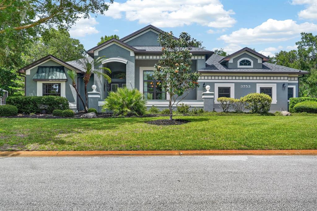 A single-story house with a gray exterior, dark roof, and a manicured front lawn — 3753 MAYO CIRCLE, ORMOND BEACH, FL