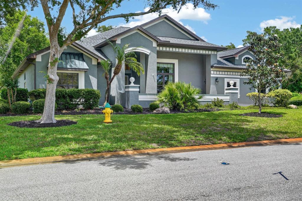 A gray, single-story house with a front porch, a yellow fire hydrant, and landscaped lawn — 3753 MAYO CIRCLE, ORMOND BEACH, FL