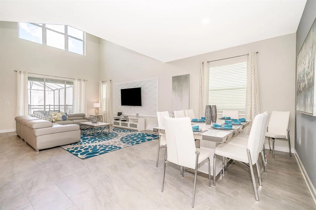 An open-concept living room and kitchen featuring a large sectional sofa and dining area — 2770 BOOKMARK DRIVE, KISSIMMEE, FL