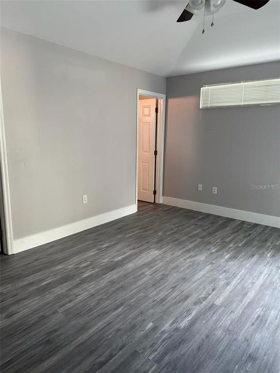 An empty room features gray walls, white trim, and dark wood-look laminate flooring — 3059 BARBADOS LANE, HAINES CITY, FL
