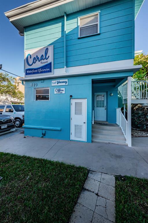 A bright blue two-story building features a Coral Resort sign and an office entrance — 483 E SHORE DRIVE UNIT A4, CLEARWATER BEACH, FL